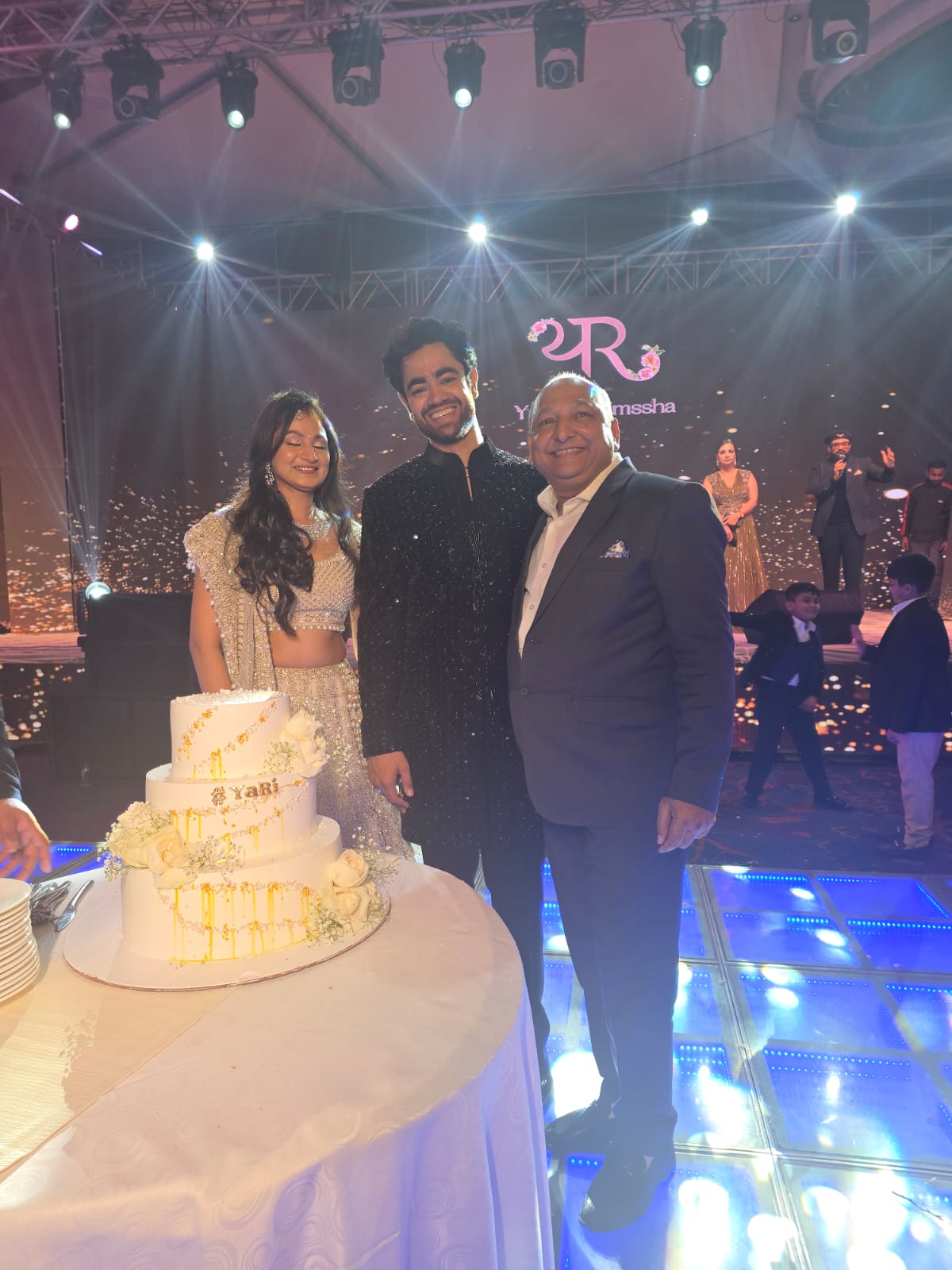 Manoj Garg with a couple beside their celebration cake