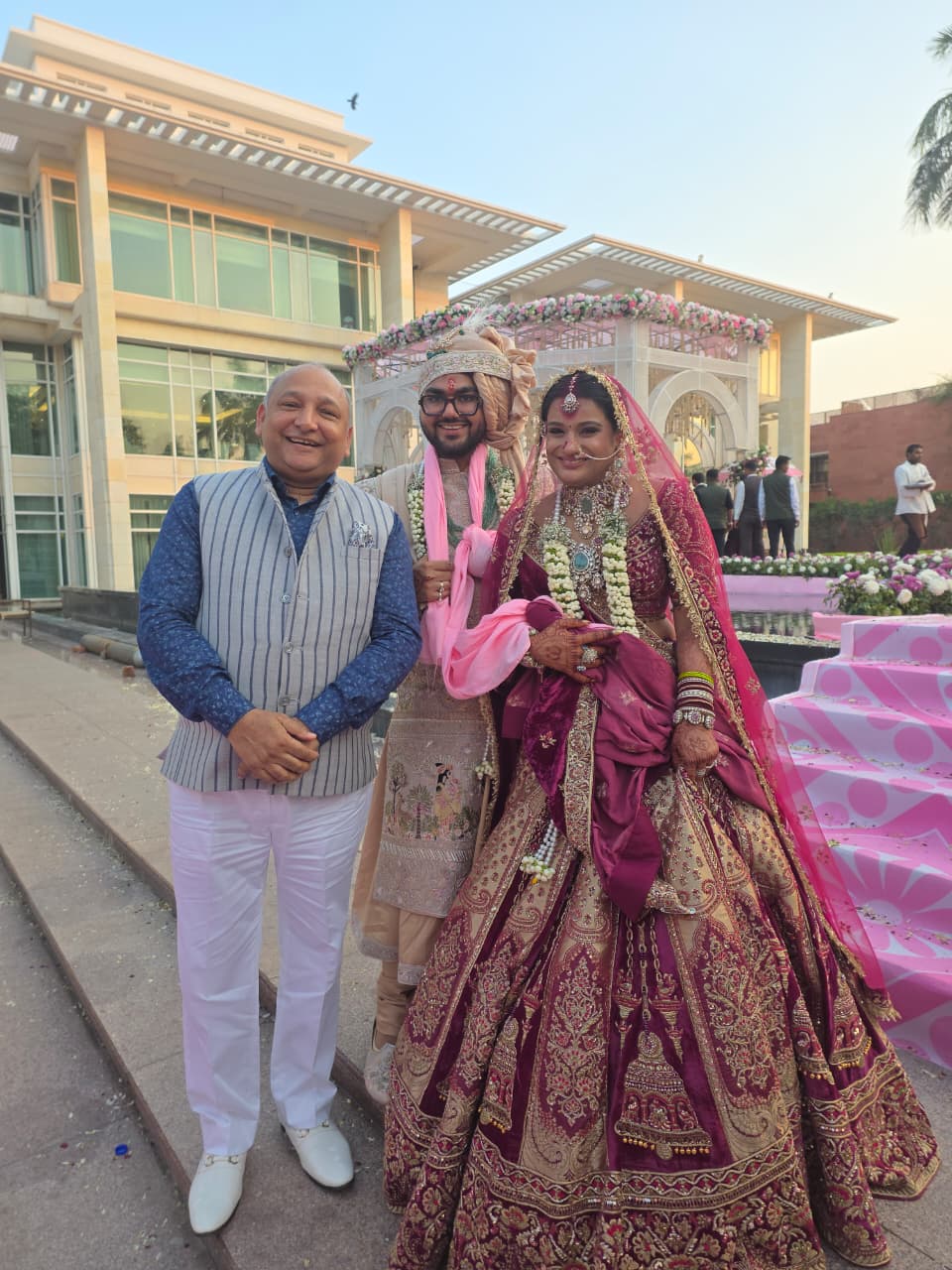 Manoj Garg with a newly married couple at an outdoor wedding